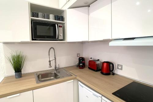une cuisine avec un évier et un micro-ondes dans l'établissement Renovated apartment AC - wifi - 2-4pers - Center Antibes rue James Close, à Antibes