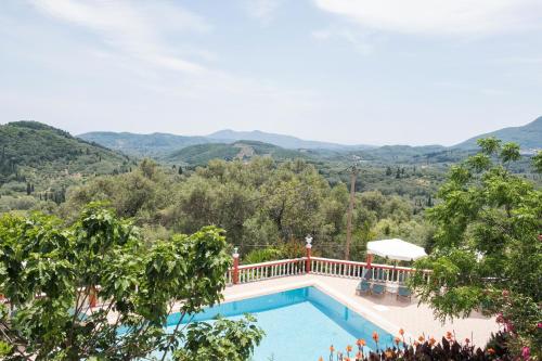 a swimming pool with mountains in the background at Villa PANGALIS Romantica in Kato Pavliana