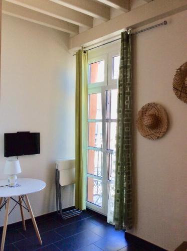 a room with a window and a table and a tv at Santa Barbara Guesthouse in Alicante