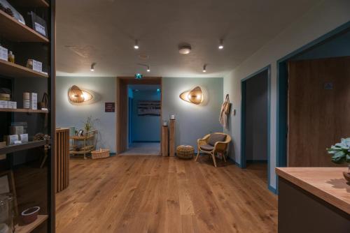 a living room with wooden floors and a blue door at Hôtel Beau Site Talloires B SPA in Talloires
