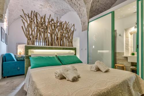een slaapkamer met een groot bed en handdoeken bij Ostuni Style - 2 Terraces with sea views in Ostuni