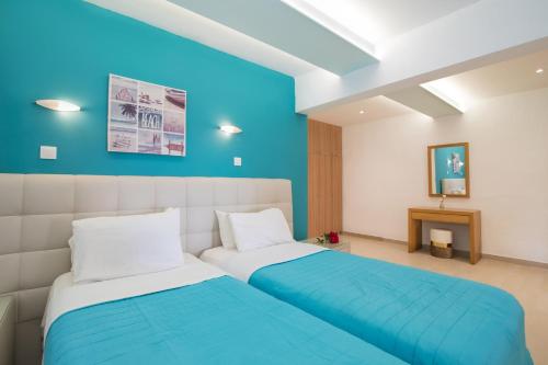 a bedroom with two beds and a blue wall at Villa PANGALIS Romantica in Kato Pavliana