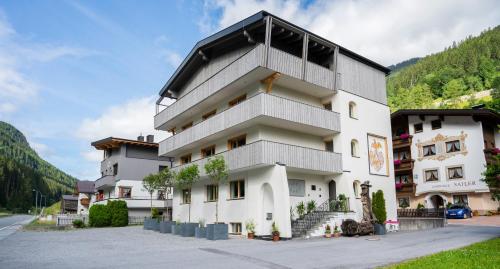 a large white building with a black roof at Kappl Apart in Kappl