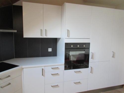 a white kitchen with white cabinets and a stove at good bed Niederbipp 13 in Niederbipp