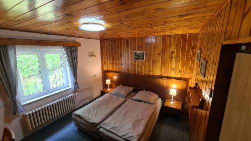een slaapkamer met een bed en twee lampen op tafels bij Chata Viktorka in Malá Morávka