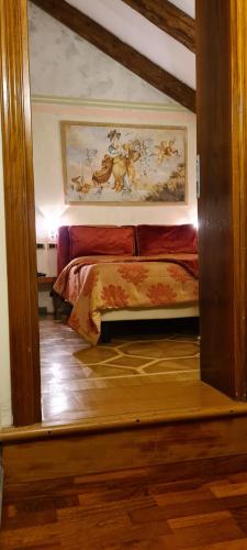 a bedroom with a bed with a painting on the wall at Hotel Villa Stucky in Mogliano Veneto