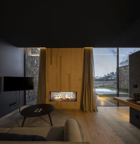 a living room with a fireplace and a couch at Monverde - Wine Experience Hotel - by Unlock Hotels in Amarante