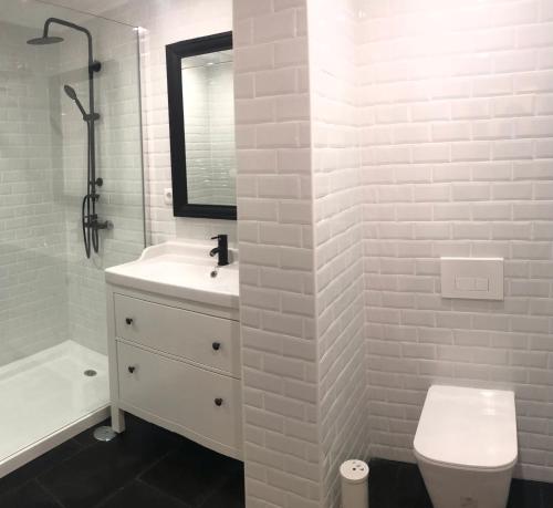 Baño blanco con lavabo y aseo en Apartamento Espaçoso Sesimbra en Sesimbra