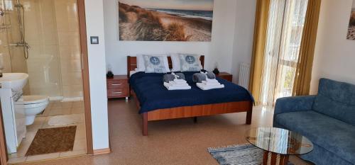 a bedroom with a blue bed and a blue couch at Villa Kapitańska in Kołobrzeg