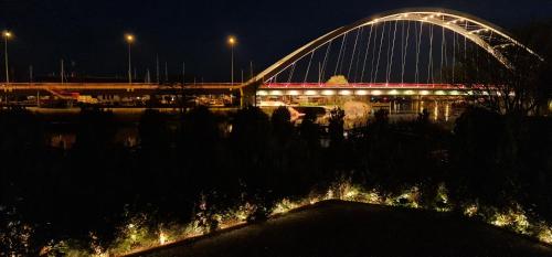 a bridge over a river at night with lights at Villa Kapitańska in Kołobrzeg