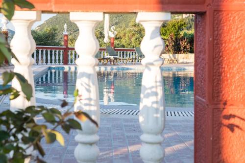a view of a pool from the porch of a house at Villa PANGALIS Romantica in Kato Pavliana