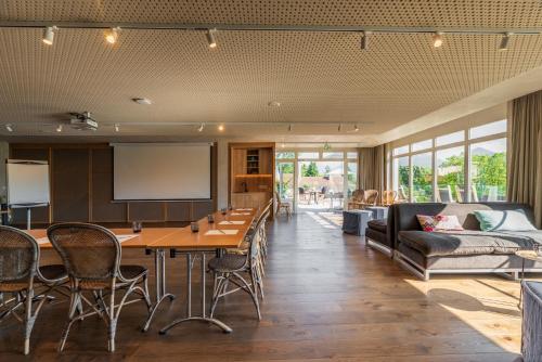 a living room with a table and a couch at Hôtel Beau Site Talloires B SPA in Talloires
