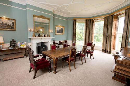 a dining room with a table and chairs and a fireplace at Burton Court in Dilwyn