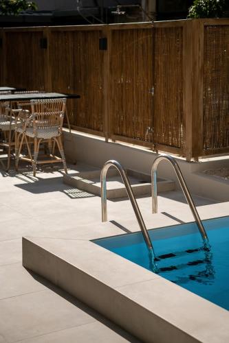 a swimming pool with two faucets next to a table at Cocoon City Hostel in Chania Town