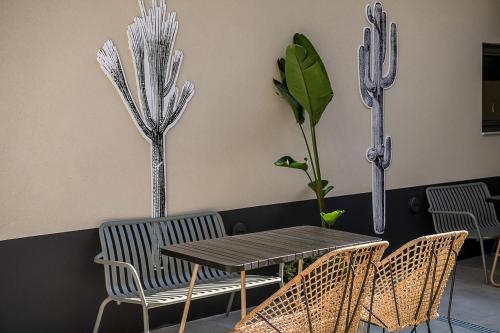 a table and chairs in a room with cactus at Cocoon City Hostel in Chania Town