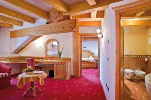 Cette chambre comprend un lavabo et un bureau. dans l'établissement Hotel Lagorai Resort & Spa, à Cavalese