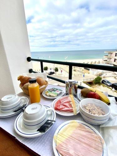 a table with food and a view of the beach at Hotel Residencial Salema in Salema