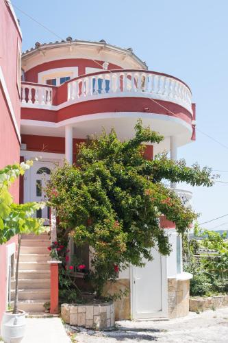 a red building with a tree in front of it at Villa PANGALIS Romantica in Kato Pavliana