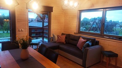 a living room with a couch and a table at Domek Nad Stawem Całoroczny in Mrągowo