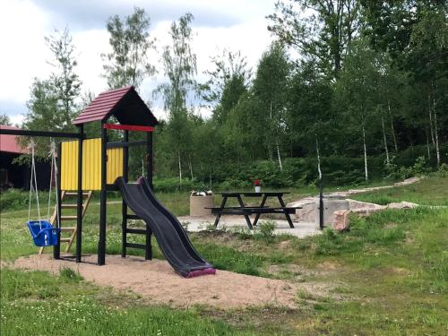 um parque infantil com escorrega e uma mesa de piquenique em Joarsbo, Stuga 2, Gårdsstugan em Kalv