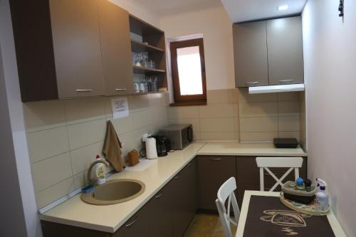 a small kitchen with a sink and a table at AnaMaria Apartments Mamaia Nord in Mamaia Sat/Năvodari
