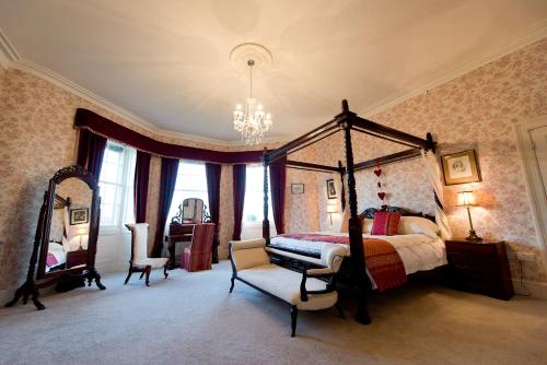 a bedroom with a canopy bed and a chair at Burton Court in Dilwyn