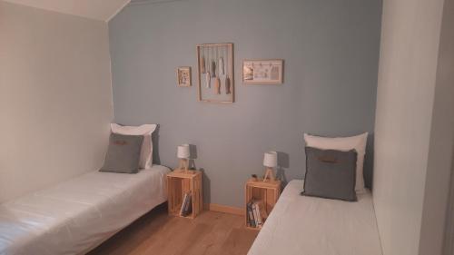 a room with two beds and two tables with lamps at Le clos des sources in Isigny-sur-Mer