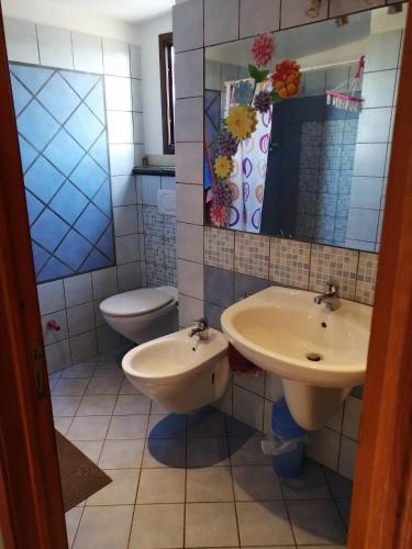 a bathroom with two sinks and a toilet at Villa Felice in Giardini Naxos