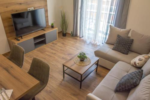 a living room with a couch and a television at Apartman Joso 2 in Sukošan