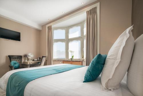 a bedroom with a large bed with a window at Hotel Maraboe in Bruges