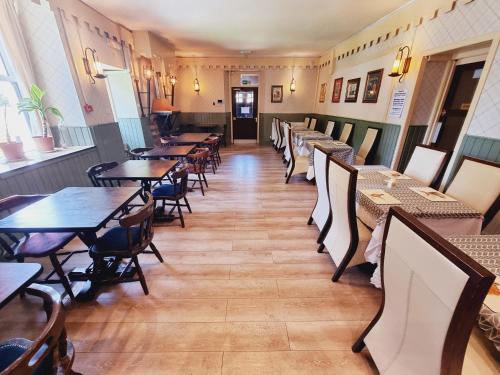 une rangée de tables et de chaises dans un restaurant dans l'établissement Roy Bridge Hotel, à Fort William