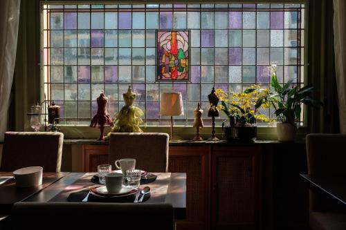 a dining room with a table and a stained glass window at Hotel Maraboe in Bruges