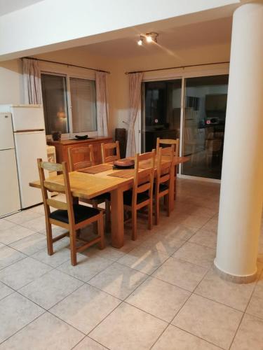 a kitchen with a wooden dining table and chairs at Villa Vista in Paphos City