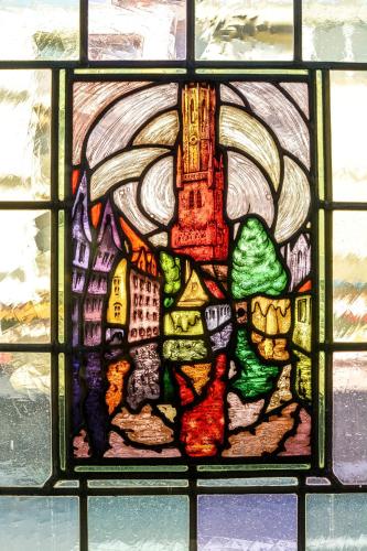 aieval stained glass window of a city with a castle at Hotel Maraboe in Bruges