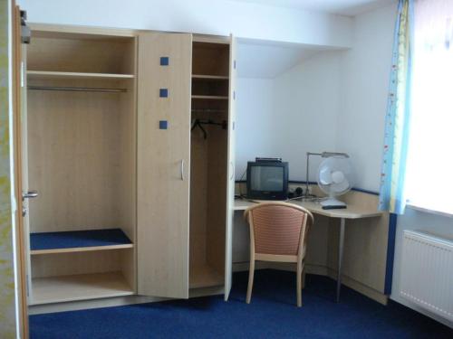 a room with a desk and a bed and a computer at Pension zur Einkehr in Allersberg