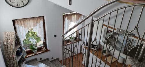 a staircase with two windows and a clock on the wall at Villa Kapitańska in Kołobrzeg