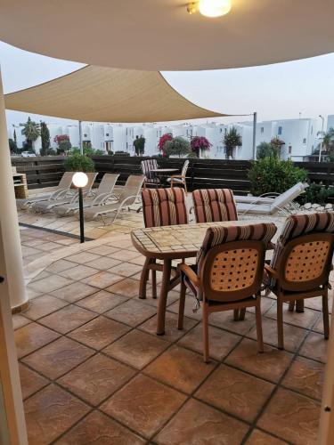 a patio with a table and chairs and an umbrella at Villa Vista in Paphos City