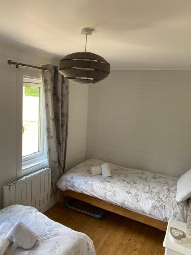 a bedroom with two beds and a chandelier at Hatton Lodge in Dunkeld