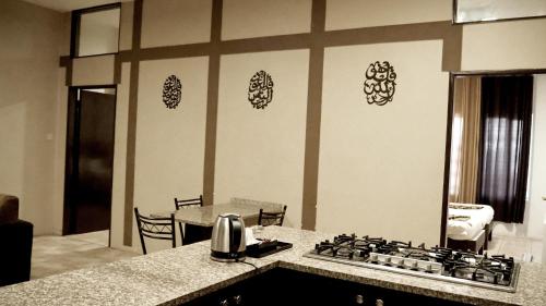 a kitchen with a stove and a counter top at Al Fawanes Hotel Apartments in Amman
