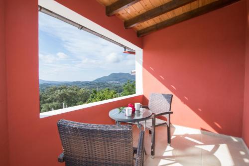 a patio with a table and chairs and a large window at Villa PANGALIS Romantica in Kato Pavliana