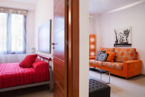 a living room with a couch and a chair at Real de Cartuja Apartments & Suites in Granada