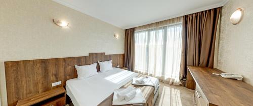 a hotel room with a bed and a window at Hotel Pautalia in Sunny Beach