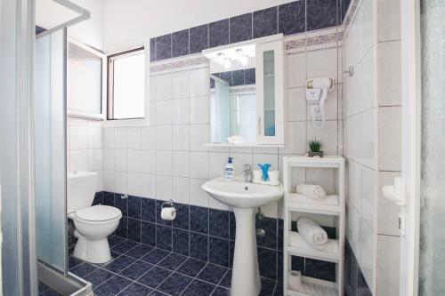 a bathroom with a sink and a toilet and a mirror at Villa PANGALIS Romantica in Kato Pavliana