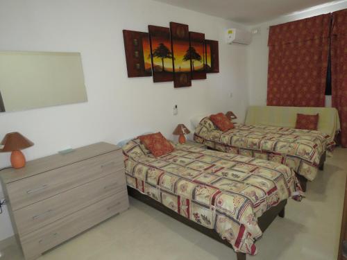1 dormitorio con 2 camas, tocador y espejo en Aquamarine Sea Front Apartments - Second Floor, en Marsaskala