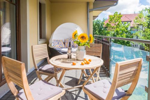 una mesa con flores y naranjas en el balcón en Wille Polanica MyWeek en Polanica-Zdrój