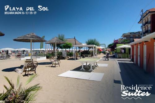 a patio with chairs and umbrellas on a beach at Residence & Suites in Bellaria-Igea Marina