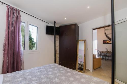 a bedroom with a bed and a mirror at Villa PANGALIS Romantica in Kato Pavliana