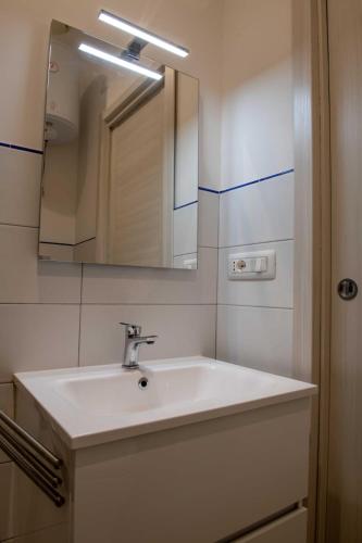 a bathroom with a white sink and a mirror at Cala Di Luna House in Vietri sul Mare