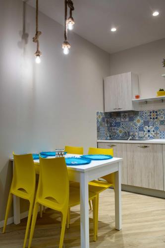 a kitchen with a table and yellow chairs at Cala Di Luna House in Vietri sul Mare