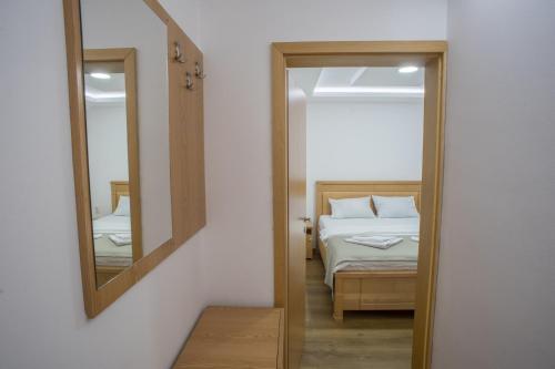 a bedroom with a bed and a mirror at Hotel Pavlović in Žabljak